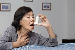 old woman about to take her inhaler