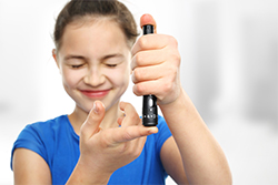 child putting insulin in finger