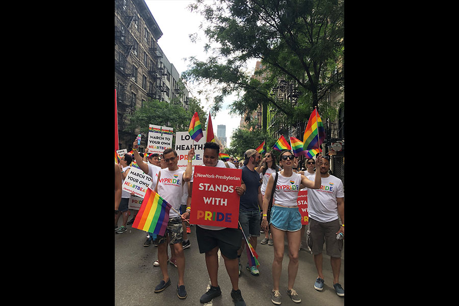 a group of people marching with signs at pride parade