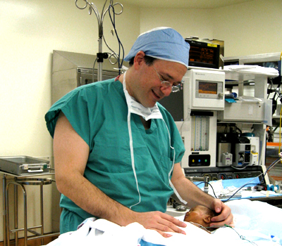 A pediatric surgeon looking at a newborn child
