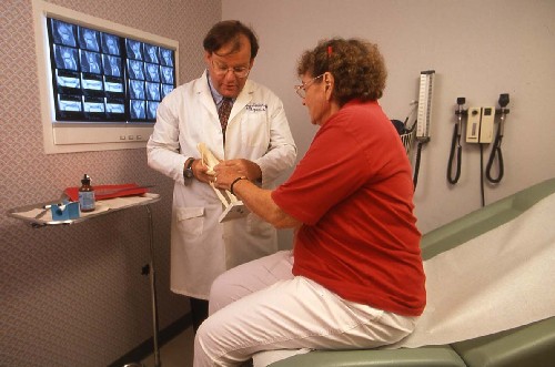 a doctor examining an elderly patient's hand