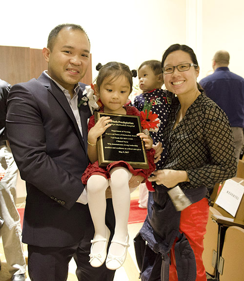 Noel Emde, R.N., critical care nurse, won the Nurse of Distinction Award and celebrated with his wife and children.