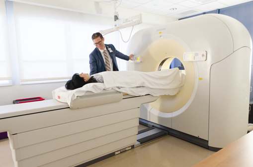 A man operating Ct scan machine as patient enters