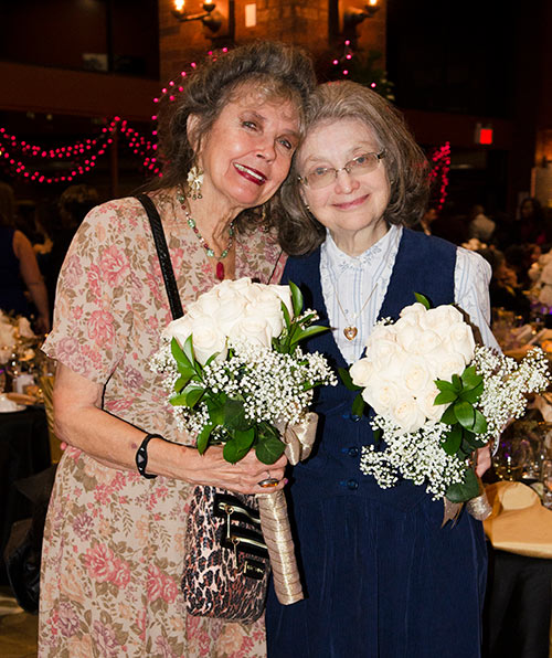 Two elderly women holding flowers