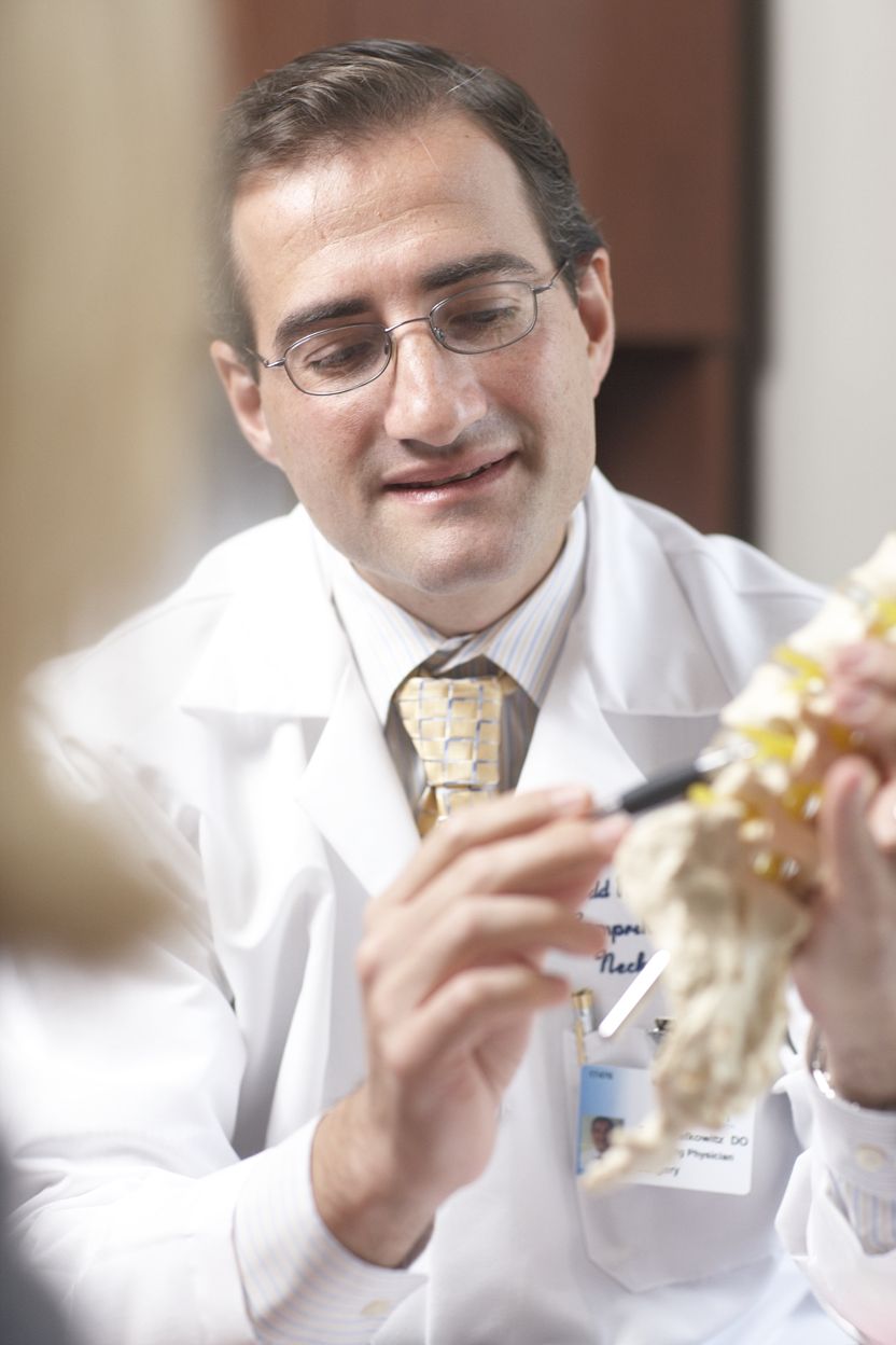 Dr. Todd Lefkowitz explaining something with a model of the spine
