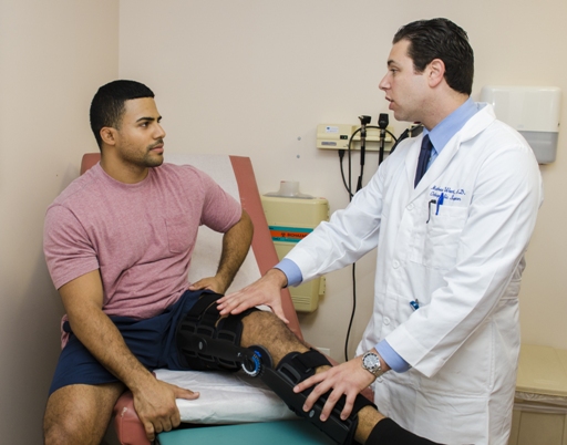 Doctor explaining to a patient while pointing at their leg