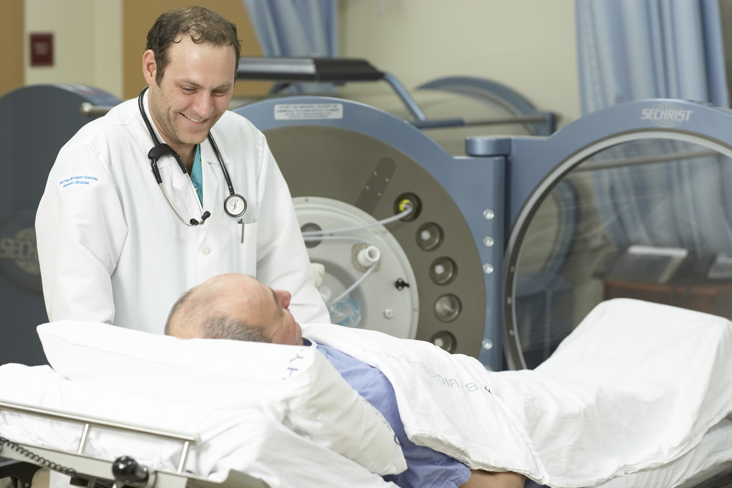A doctor talking to a man in a hospital bed