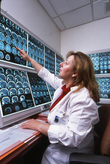 doctor pointing at brain scans on screen