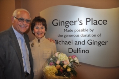 A man and woman standing next to a sign that says Ginger's Place