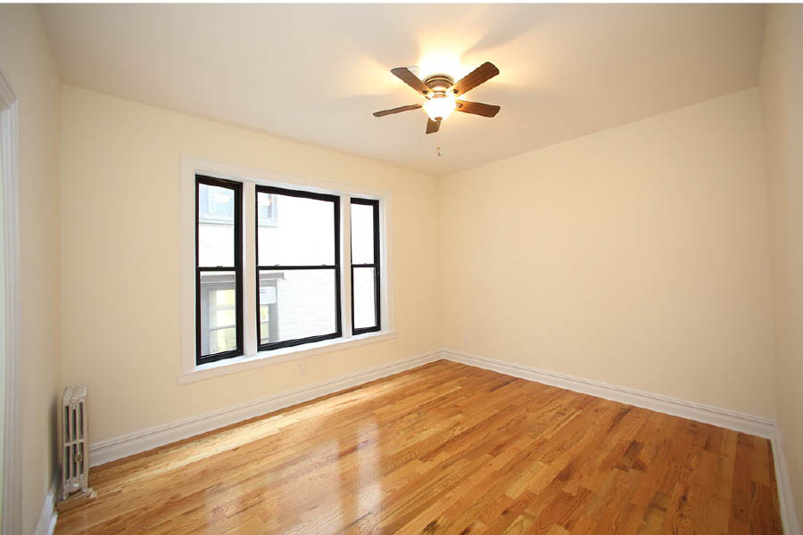 a room with a wood floor and a ceiling fan at 600 West 169 Street