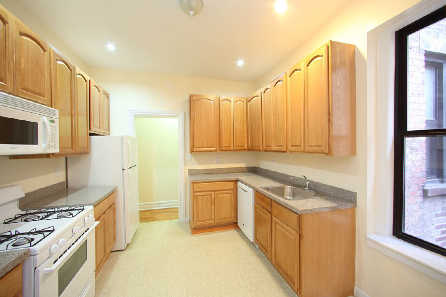 a kitchen with wooden cabinets at 600 West 169 Street