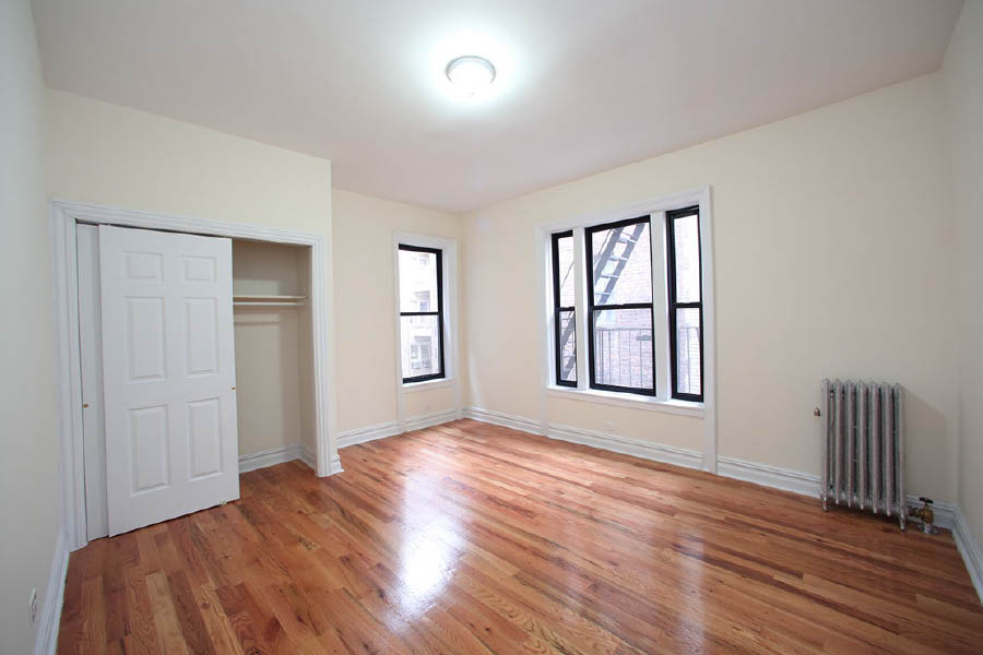 a room with a wood floor and windows at 600 West 169 Street