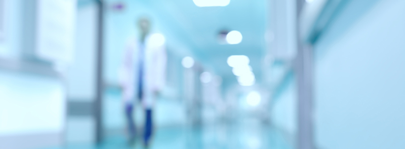 A blurry image of a doctor walking through a hallway