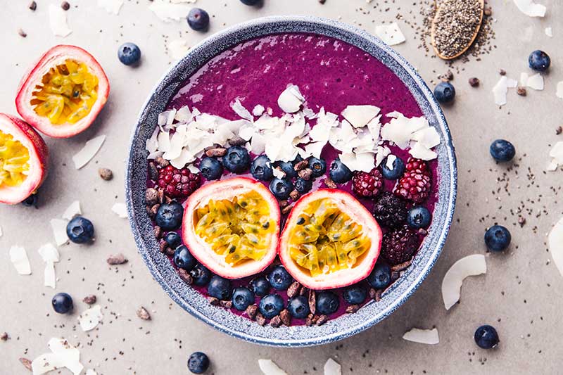 image of smoothie acai bowl served in bowl on grey table