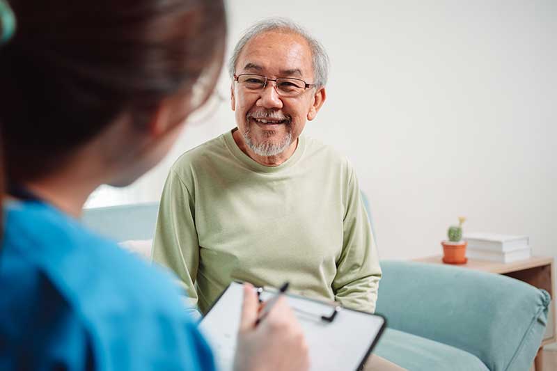 elderly man speaking with nurse