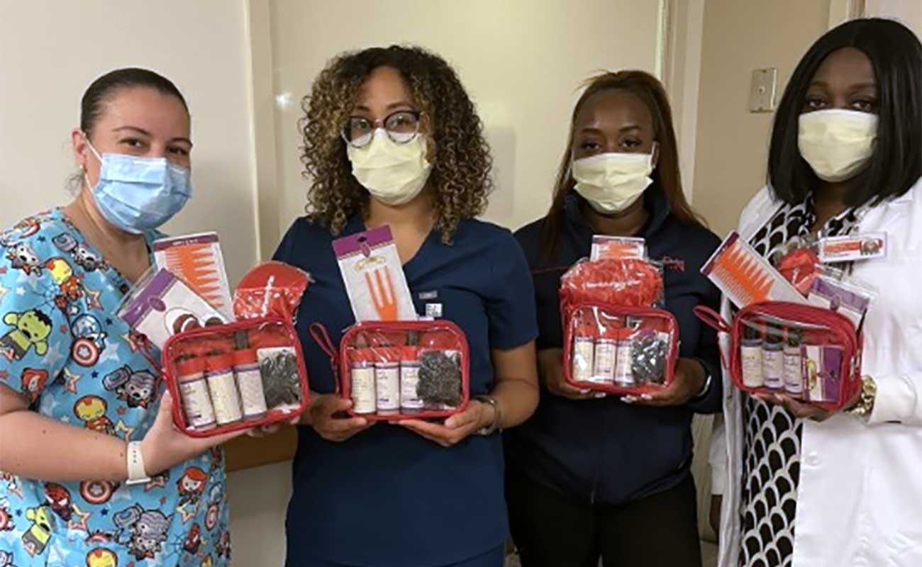 Four women holding baskets of hair products