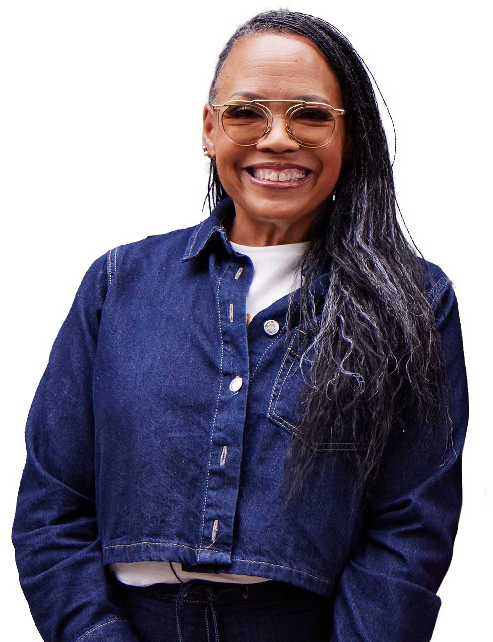 Smiling African American woman wearing gold-rimmed glasses, a white top, and a cropped dark denim jacket. She has long, straight dark hair swept to one side.