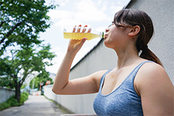 a woman drinking out of a water bottle