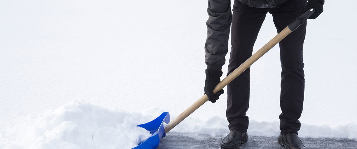 An adult shoveling snow