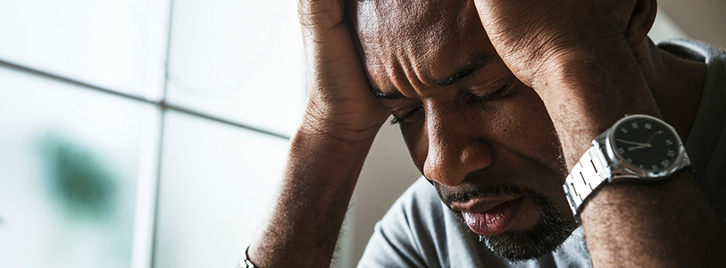 black man holding his head