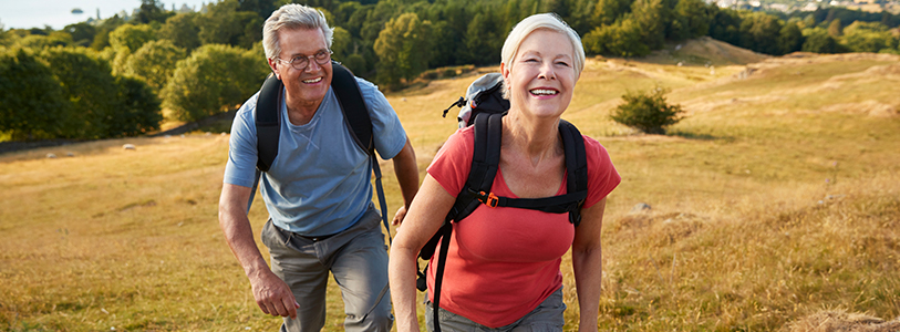 man and woman smiling while hiking