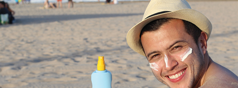 man with hat wearing sunscreen