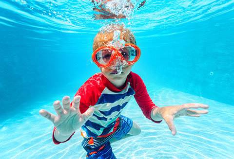 boy wearing goggles underwater