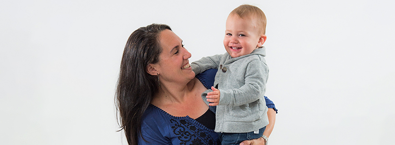 mother holding baby smiling