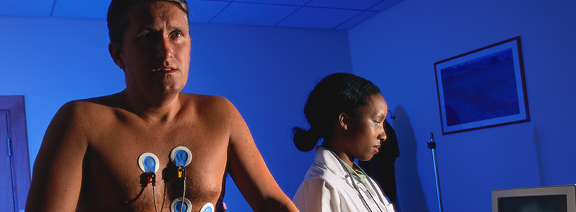 patient hooked up to machine while doctor looks at computer 