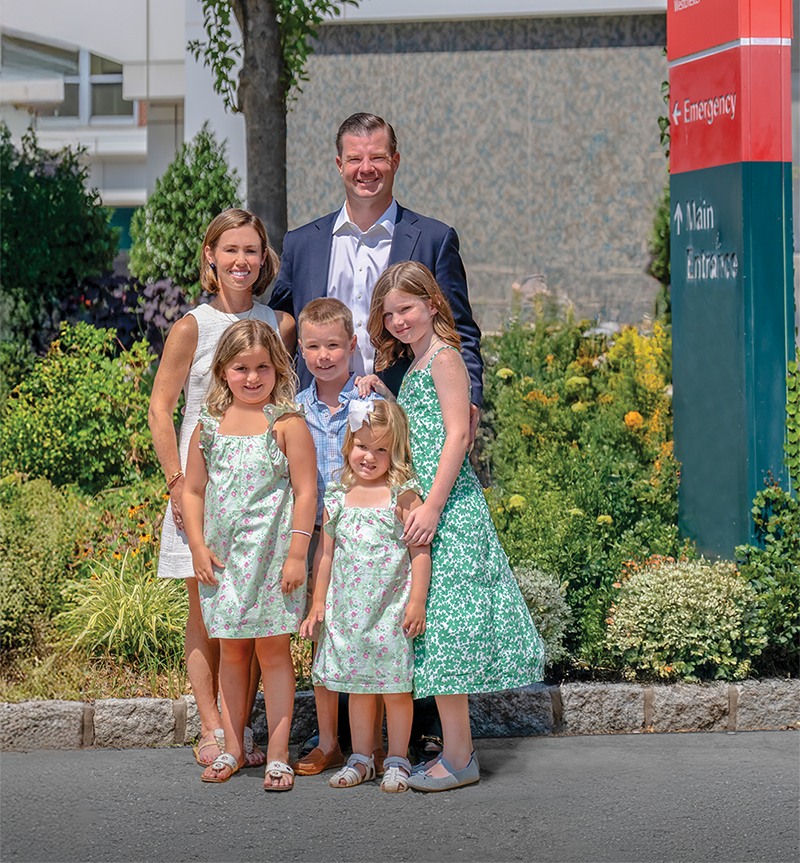 Formally dressed family outside.