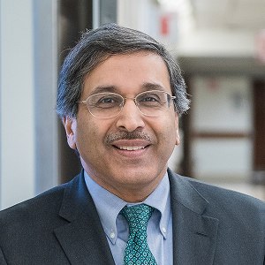 a man with glasses smiling straight ahead at viewer