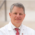 A man in a doctor's coat and wearing a tie.