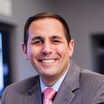 Man smiling in pink tie.