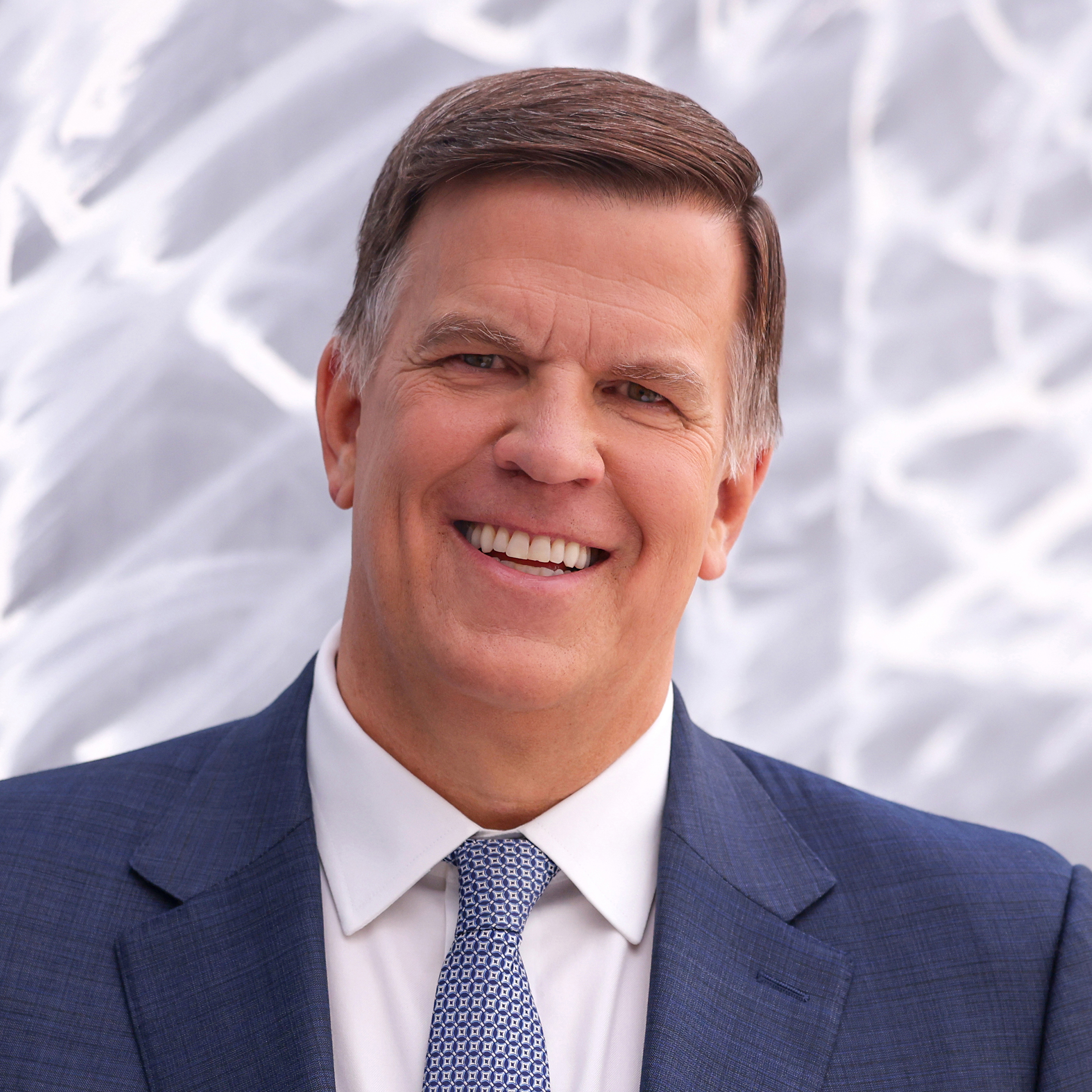 A smiling man in a suit and tie.