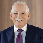 A man with white hair in a suit.