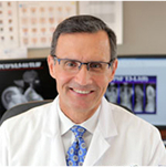 A white man in a lab coat and tie.