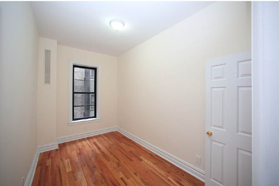 a room with white walls and a wood floor at 600 West 169 Street
