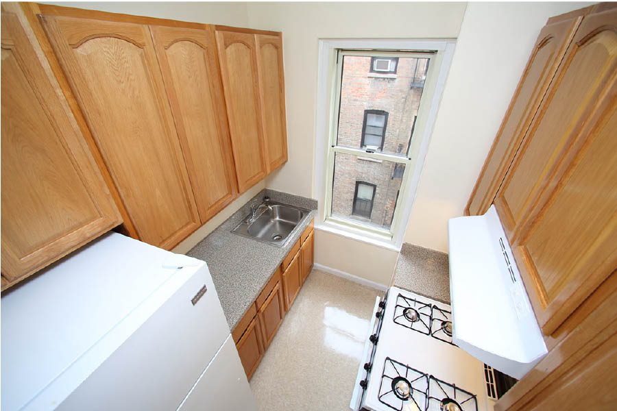 a kitchen with wooden cabinets at 625 West 169 Street