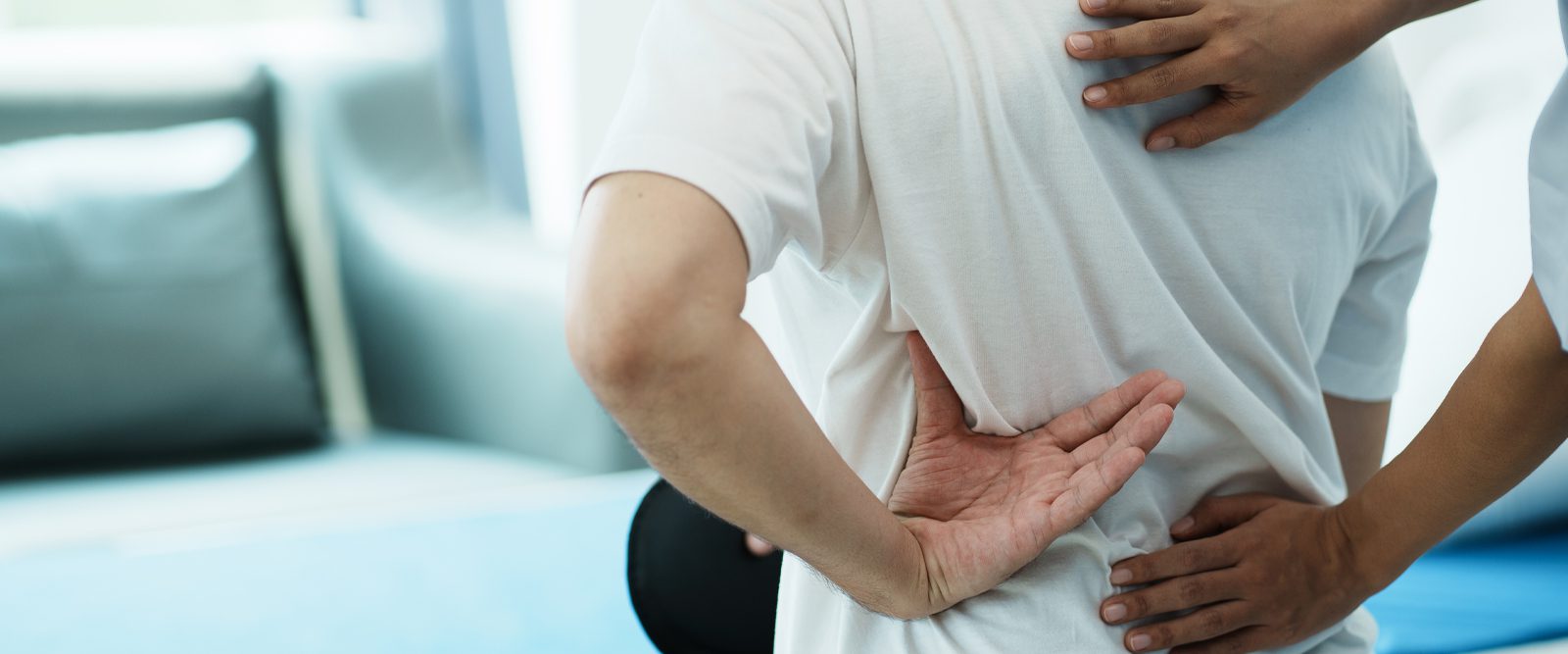 A caregiver helps adjust a patient's back