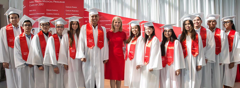 Group of Lang Youth Medical Program wearing white gowns and red sash