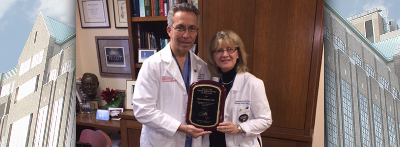 Two doctors holding an award together