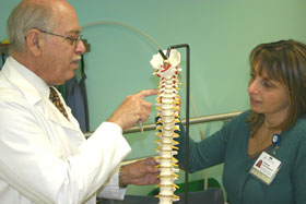a man and a woman looking at spine skeleton