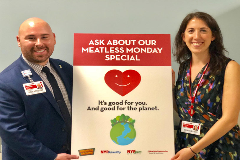 A man and woman holding a sign advertising the meatless monday special