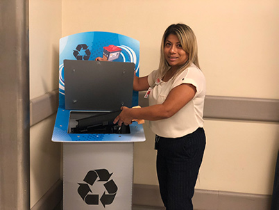 A woman demonstrating how to use a recycling bin
