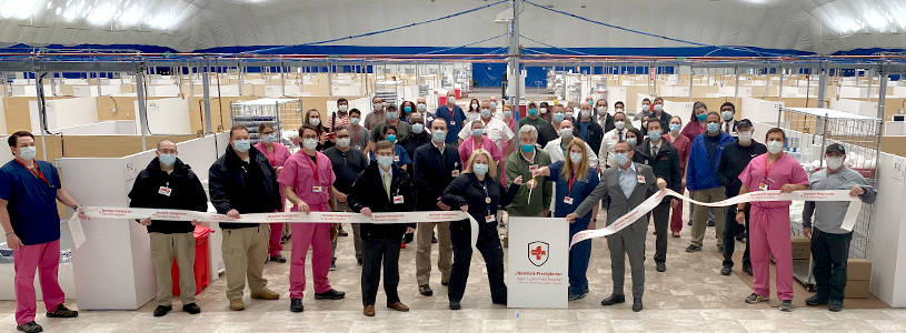 A group of people posing for a photo as the ribbon is cut