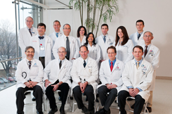 A large group of doctors in lab coats posing for a photo