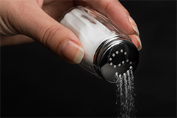 A close up of someone pouring salt
