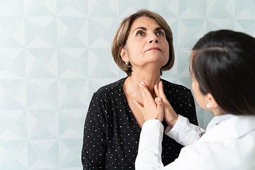 female doctor examining female patients neck