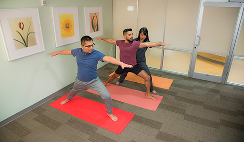Instructor correcting person's yoga pose