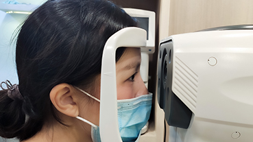 image of a patient wearing a mask getting eye exam